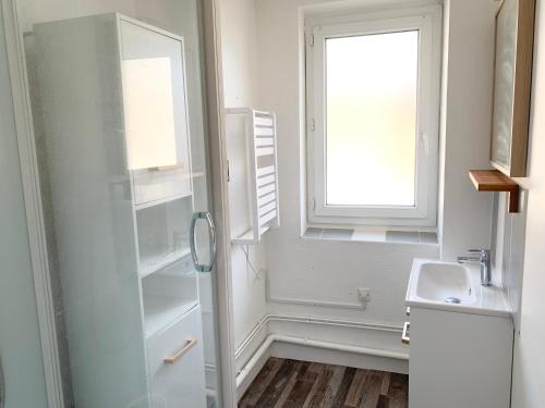 biała łazienka z umywalką i oknem w obiekcie Nacre - 400m de la mer - Juno Beach w mieście Bernières-sur-Mer