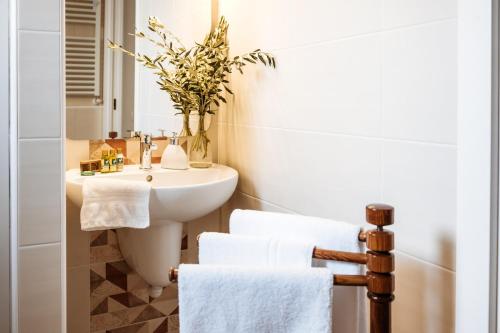 La salle de bains est pourvue d'un lavabo, d'un miroir et de serviettes. dans l'établissement Casa Due Marie Marano sul Panaro, à Marano sul Panaro