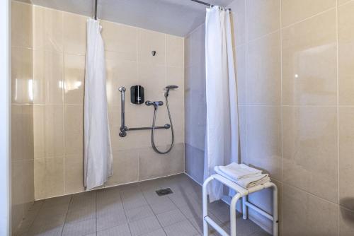 y baño con ducha y cortina de ducha. en B&B HOTEL Perpignan Sud Porte d'Espagne en Perpiñán