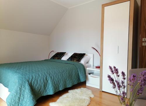 a bedroom with a green bed and a mirror at Apartament Wschód Słońca Olecko in Olecko