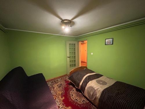 グダニスクにあるApartament Mickiewiczaの緑の壁のベッドルーム1室(ベッド1台付)