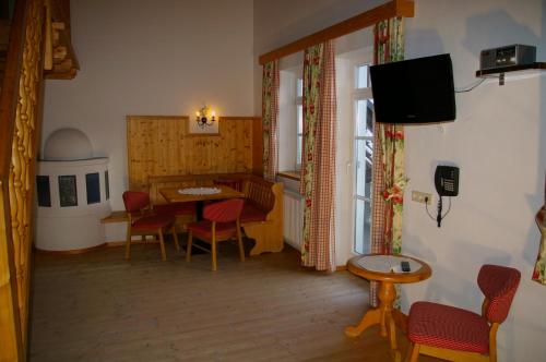 a dining room with a table and chairs and a television at Appartement Wildspitz' in Vent