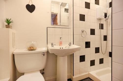 e bagno con servizi igienici, lavandino e doccia. di Dalmeny Street Apartment a Edimburgo