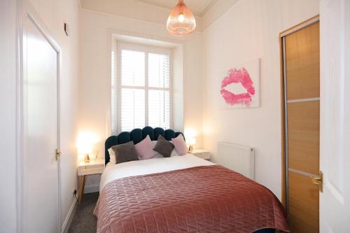 ein Schlafzimmer mit einem großen Bett mit einer roten Decke in der Unterkunft Dalmeny Street Apartment in Edinburgh