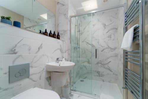 a bathroom with a shower and a toilet and a sink at Apartment One - King Bed - Free Private Parking - by Ocean City Retreats in Plymouth