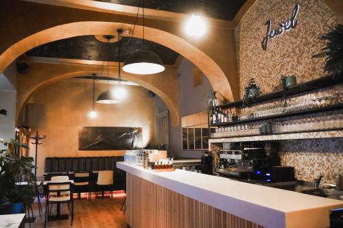 プラハにあるデザイン ホテル ジュエル プラハのカウンターと椅子付きのレストランのバー