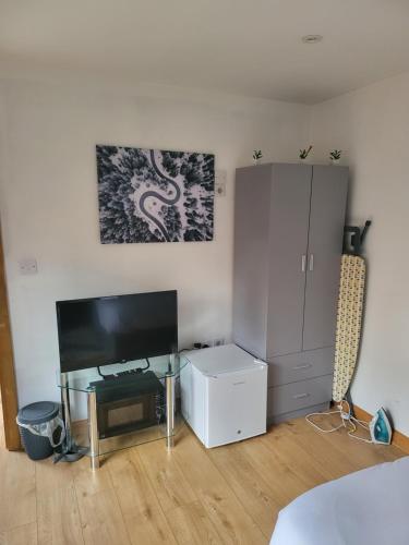 a living room with a television and a cabinet at Midway in Garston