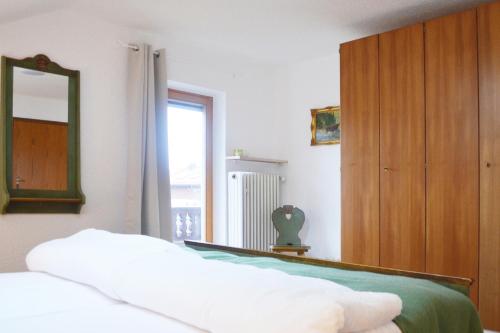 1 dormitorio con cama, espejo y ventana en Ferienhaus Antdorfer Gartenglück en Antdorf