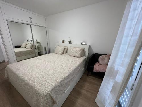 a white bedroom with a bed and a mirror at Piteras Las Americas in Arona