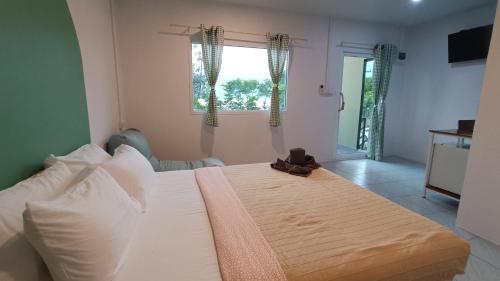 um quarto com uma cama branca e uma janela em เลคแค้มป์ รีสอร์ท em Kathun