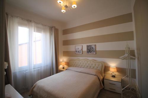 a bedroom with a bed and a striped wall at Secondopiano in Pisa