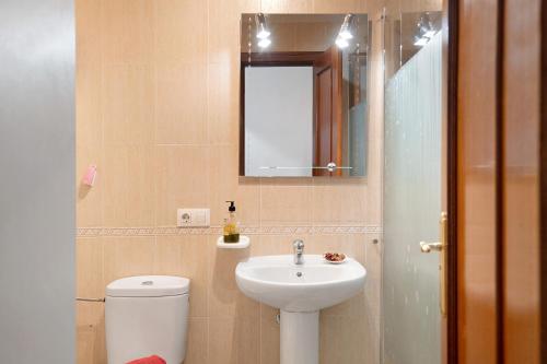 a bathroom with a sink and a toilet and a mirror at Un Oasis en Arrecife in Arrecife