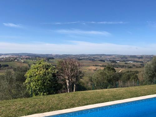 a swimming pool with a view of the countryside at Casa do Horizonte in Bombarral