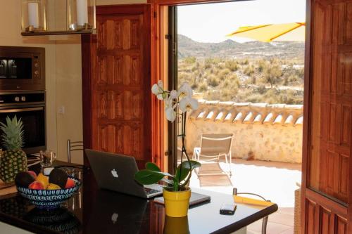 a kitchen with a table with a laptop and a window at Beautiful 4-Bed House in Campo de Ricote in Collado de Gil