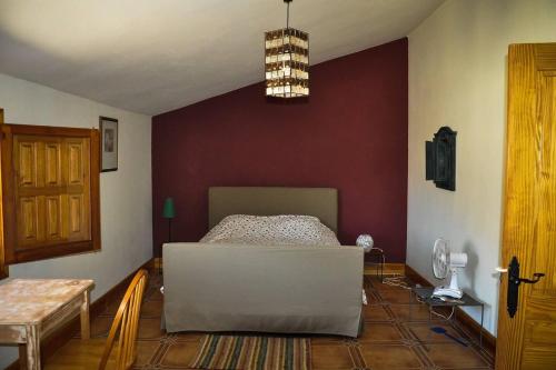 Beautiful 4-Bed House in Campo de Ricote في Collado de Gil: غرفه فيها سرير واريكه