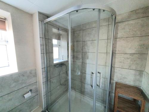 a shower with a glass door in a bathroom at Wentworth Apartment with 2 bedrooms, Superfast Wi-Fi and Parking in Sittingbourne