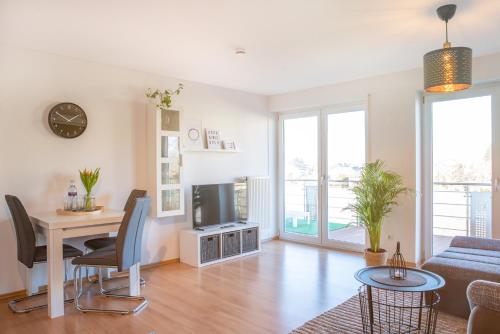 a living room with a table and a tv at FAIRflats: Küche, Balkon, Arbeitsplatz, Aufzug in Hüfingen