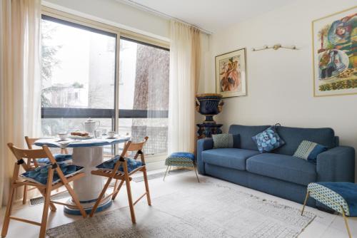 - un salon avec un canapé bleu et une table dans l'établissement LOUVRE-MONTORGEUIL PARIS HISTORICAL CENTER, à Paris