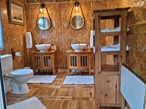 ein Badezimmer mit zwei Waschbecken und einem WC in der Unterkunft Riverside Cabin at Pen-Y-Bont Mill in Oswestry