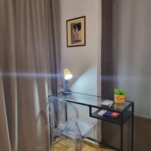 a glass desk with a lamp and a chair at GREAT APARTMENT IN VERIA in Veria