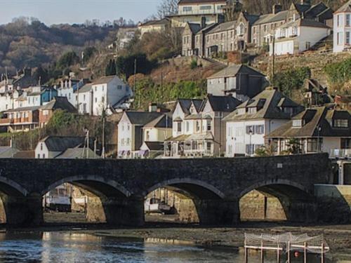 a bridge over a body of water with houses at Little Mainstone Guest House in Looe