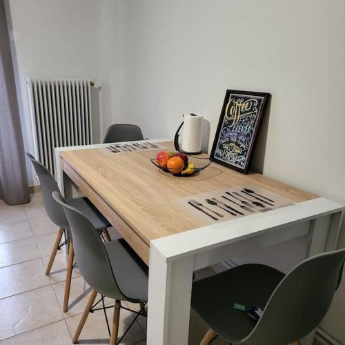 a table with chairs and a bowl of fruit on it at GREAT APARTMENT IN VERIA in Veria