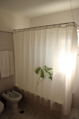 a bathroom with a shower curtain with an umbrella on it at Apartamentos King's in Quarteira