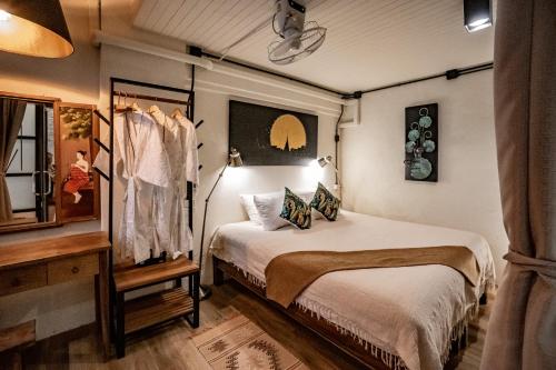 a bedroom with a bed and a mirror and a window at Luxury Industrial Flat in the Heart of Chiang Mai in Chiang Mai