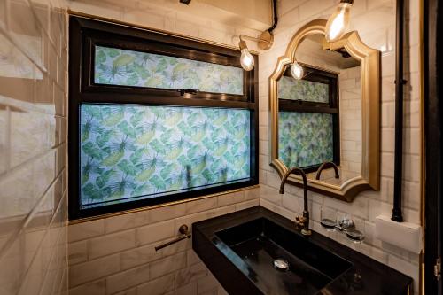 a bathroom with a sink and a window at Luxury Industrial Flat in the Heart of Chiang Mai in Chiang Mai