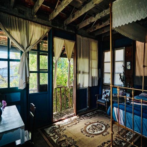 a bedroom with blue walls and a bed and windows at HEY! STORM HOME in Ấp Ða Lợi