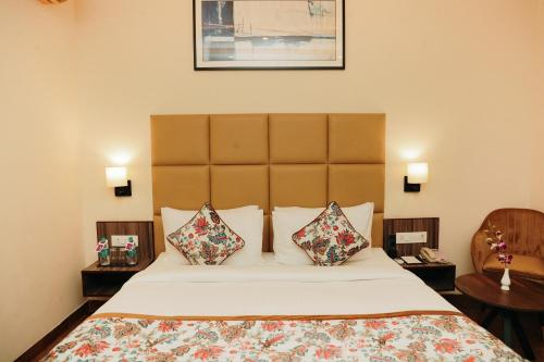 a hotel room with a bed with two pillows at Regenta Inn Greater Noida, 15 Mins to India Expo Mart in Greater Noida