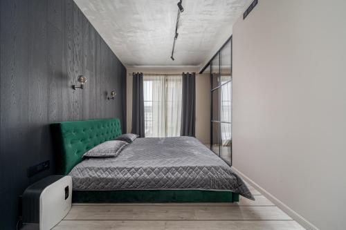 a bedroom with a bed with a green headboard at Lofts & Rosegold Luxury Stay in Elegant 1BR with Balcony in Riga Center in Rīga