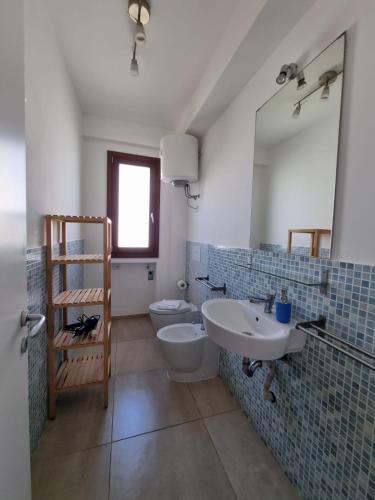 a bathroom with a sink and a toilet and a mirror at Borgo Vigata in Punta Secca