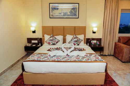 a hotel room with a bed with two shoes on it at Regenta Inn Greater Noida, 15 Mins to India Expo Mart in Greater Noida