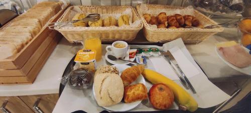 una mesa con una bandeja de pan y otros alimentos para el desayuno en Hotel Sao Mamede en Estoril