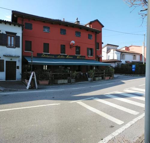 un edificio rosso sul lato di una strada di Osteria Locanda Dalla Lina a Mirano