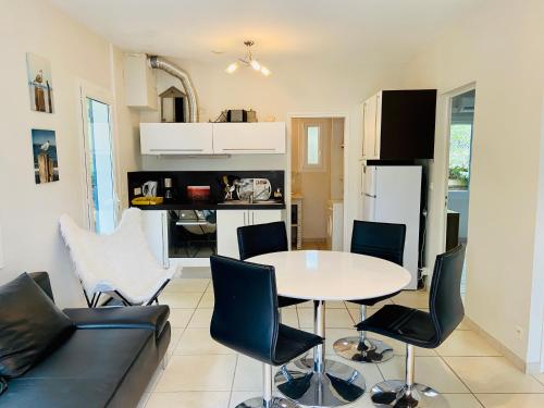 - une cuisine et une table avec des chaises dans la chambre dans l'établissement Villa Estoril Ronce les Bains, à La Tremblade