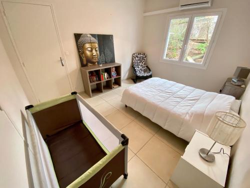 - une chambre avec un lit et une statue de tête dans l'établissement Villa Estoril Ronce les Bains, à La Tremblade