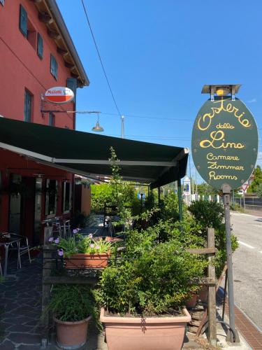 un cartello di fronte a un ristorante con piante di Osteria Locanda Dalla Lina a Mirano