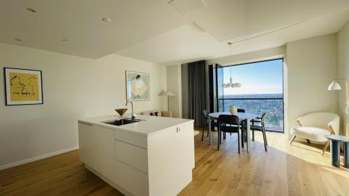 a kitchen with a sink and a table with chairs at ApartmentInCopenhagen Apartment 1530 in Copenhagen