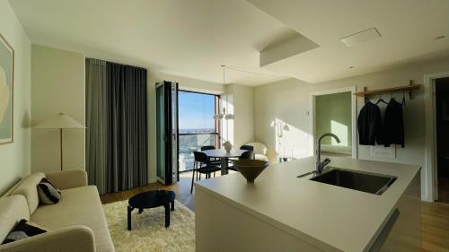 a kitchen and living room with a sink and a couch at ApartmentInCopenhagen Apartment 1530 in Copenhagen