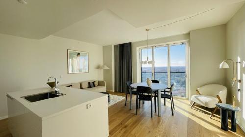a kitchen and dining room with a table and a view at ApartmentInCopenhagen Apartment 1530 in Copenhagen