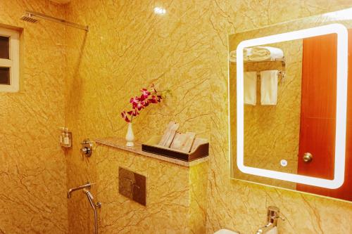 bagno con doccia, lavandino e specchio di Regenta Inn Greater Noida, 15 Mins to India Expo Mart a Greater Noida