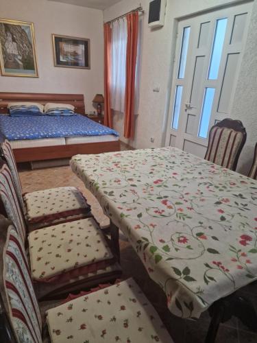 um quarto com uma mesa e cadeiras e uma cama em Apartmani Vukomanovo em Mojkovac