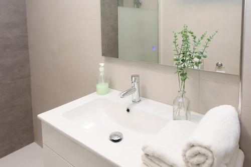 y baño con lavabo blanco y espejo. en Romántico, acogedor y moderno., en Empuriabrava