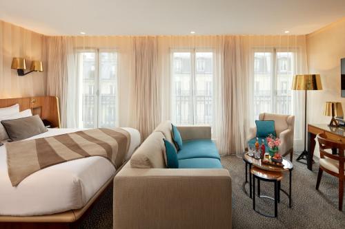 um quarto de hotel com uma cama e um sofá em Maison Albar - Le Pont-Neuf em Paris