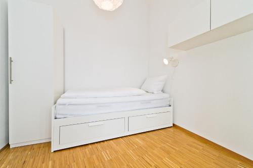 a small white room with a bed in it at Braviscasa - Ferienresidenz Stadttor Endingen in Endingen