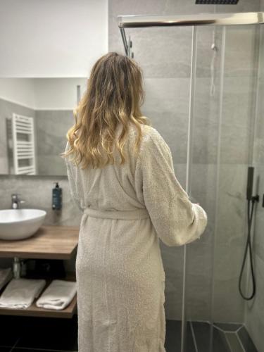 a woman standing in a shower in a bathroom at Hotel Paradiso Como in Brunate
