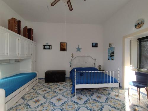 ヴィエトリにあるLa Stella Vietreseのベッドルーム1室(ベッド2台、青いベビーベッド1台付)