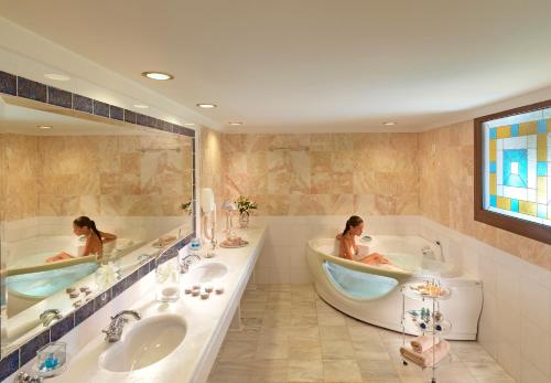 two women sitting in tubs in a bathroom at Aldemar Olympian Village in Olympia